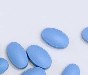 Generic sildenafil tablets, blue oval pills on a white background