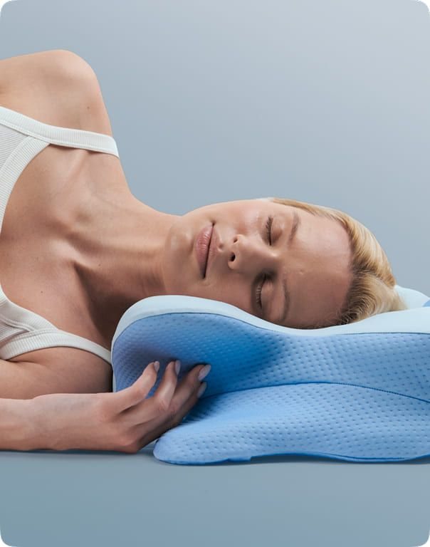 Woman sleeping on her side on the blue contoured Derila Ergo memory foam pillow