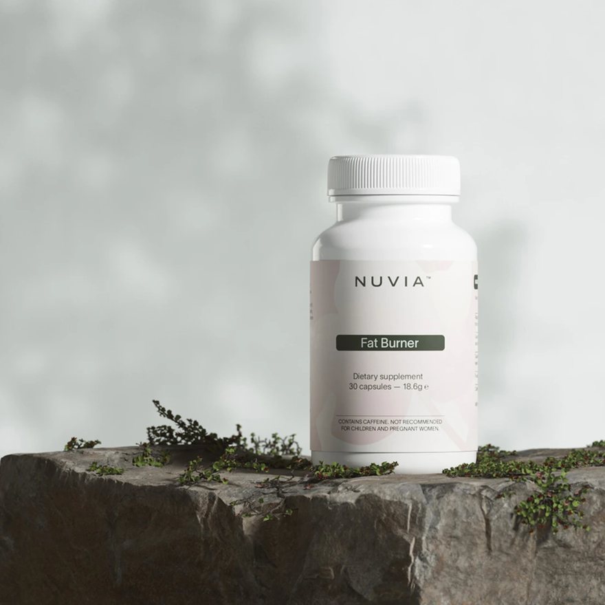 White Nuvia bottle on a rock, labelled Fat Burner, dietary supplement, 30 capsules, 18.6 g